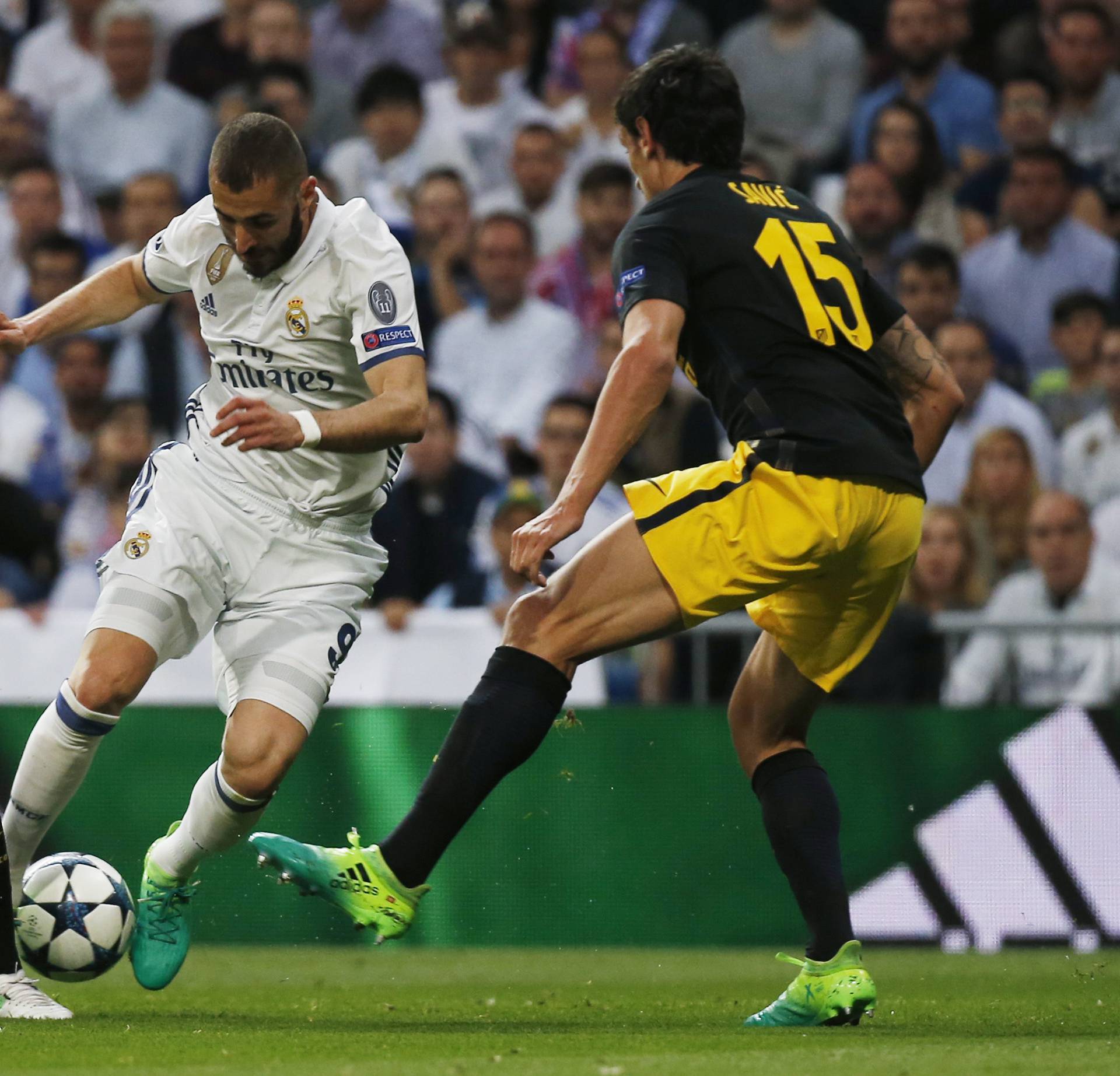 Real Madrid's Karim Benzema in action with Atletico Madrid's Lucas Hernandez and Stefan Savic