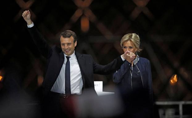 FILE PHOTO: French President elect Emmanuel Macron and his wife Brigitte Trogneux celebrate on the stage at his victory rally near the Louvre in Paris
