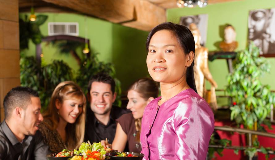 Young,People,Eating,In,A,Thai,Restaurant;,The,Waitress,Brings