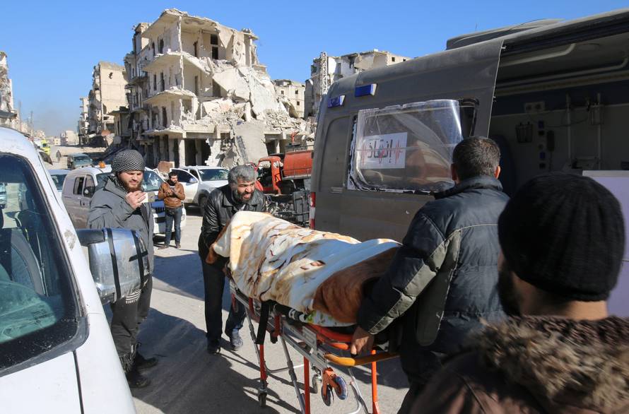 Men push an evacuee on a stretcher as vehicles wait to evacuate people from a rebel-held sector of eastern Aleppo