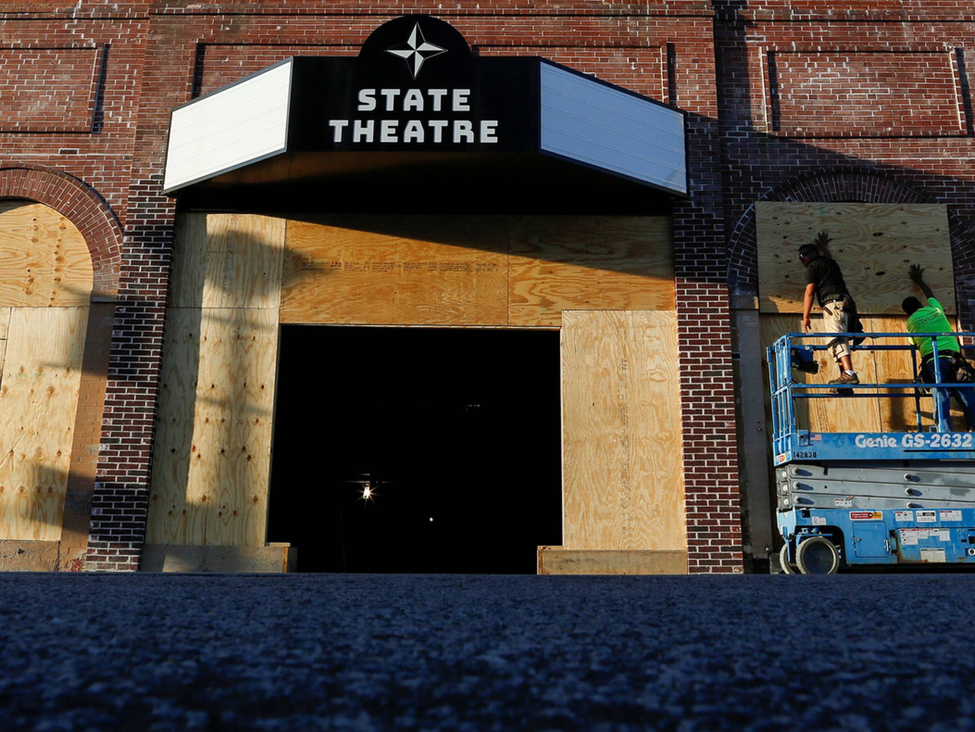 People put plywood up on the windows of a theatre before the arrival of Hurricane Florence in Greenville