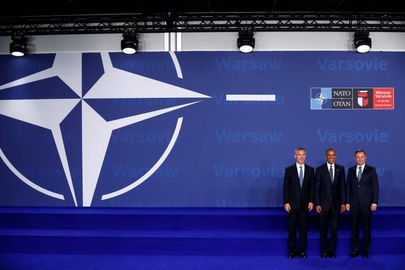 Obama stands with Stoltenberg and Duda during his official arrival at the NATO Summit in Warsaw, Poland