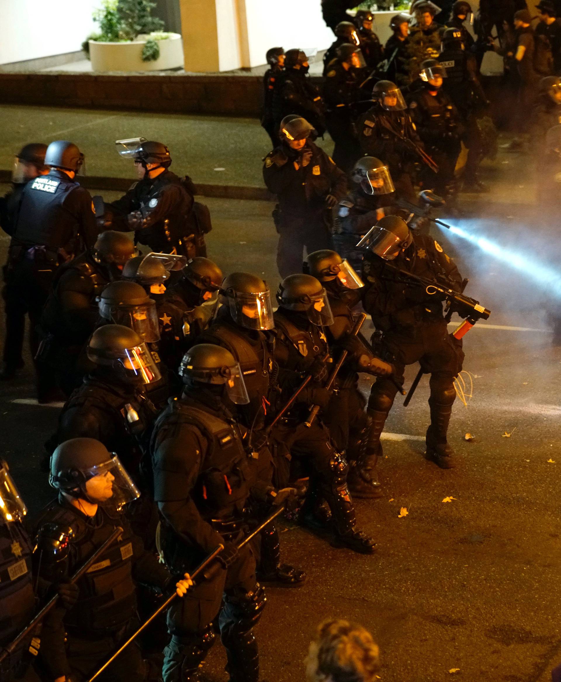 A police officer sprays the crowd with an irritant during a protest against the election of Republican Donald Trump as President of the United States in Portland, Oregon