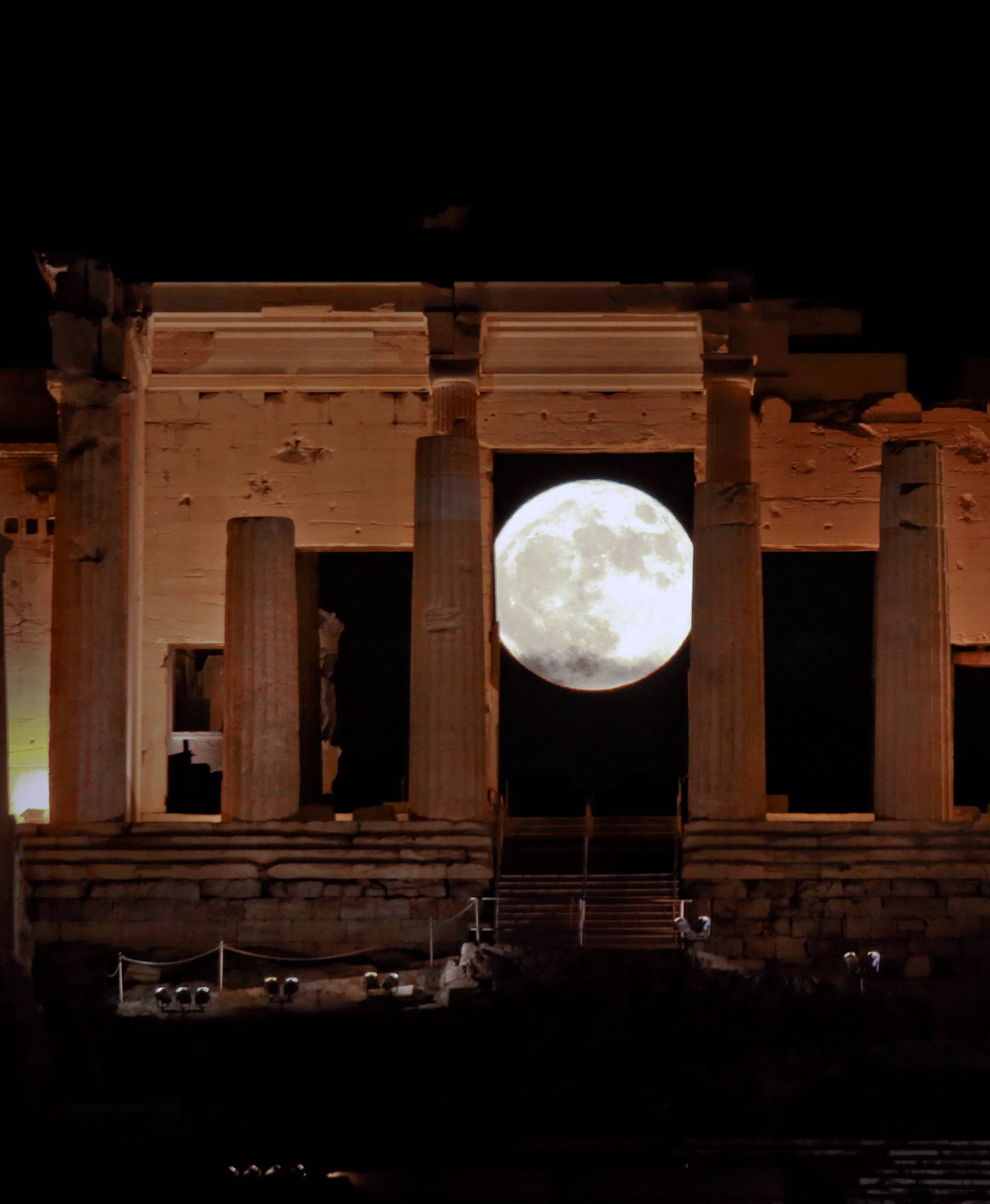 A rising "supermoon" is seen through the Propylaea, the ancient Acropolis hill gateway, in Athens