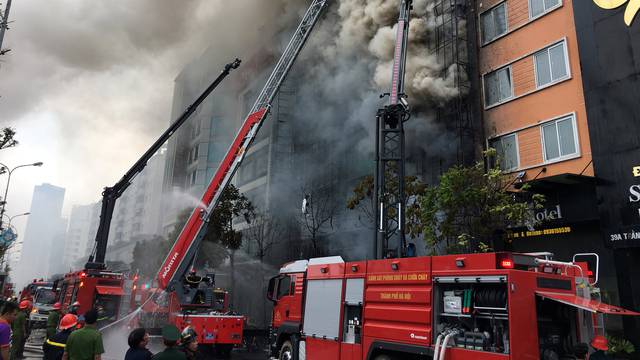 Firefighters work after a fire broke out at a karaoke lounge in Hanoi