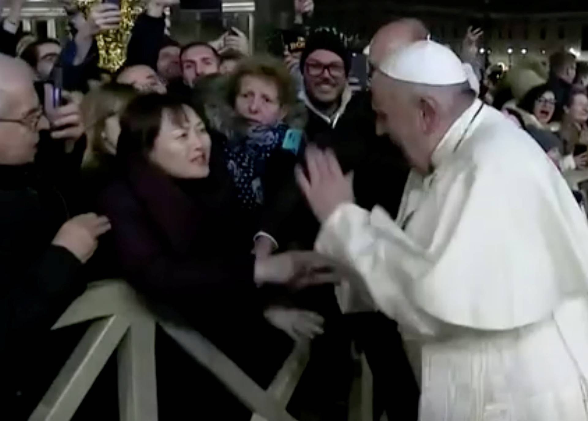 Pope Francis slaps the hand of a woman who grabbed him, at Saint Peter's Square at the Vatican