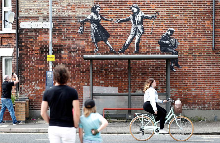 People stop to look at artwork created by Banksy in Great Yarmouth