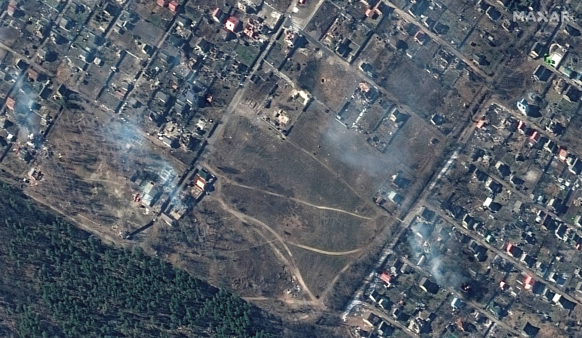 A satellite image shows a natural color closer view of burning homes, in Moschun