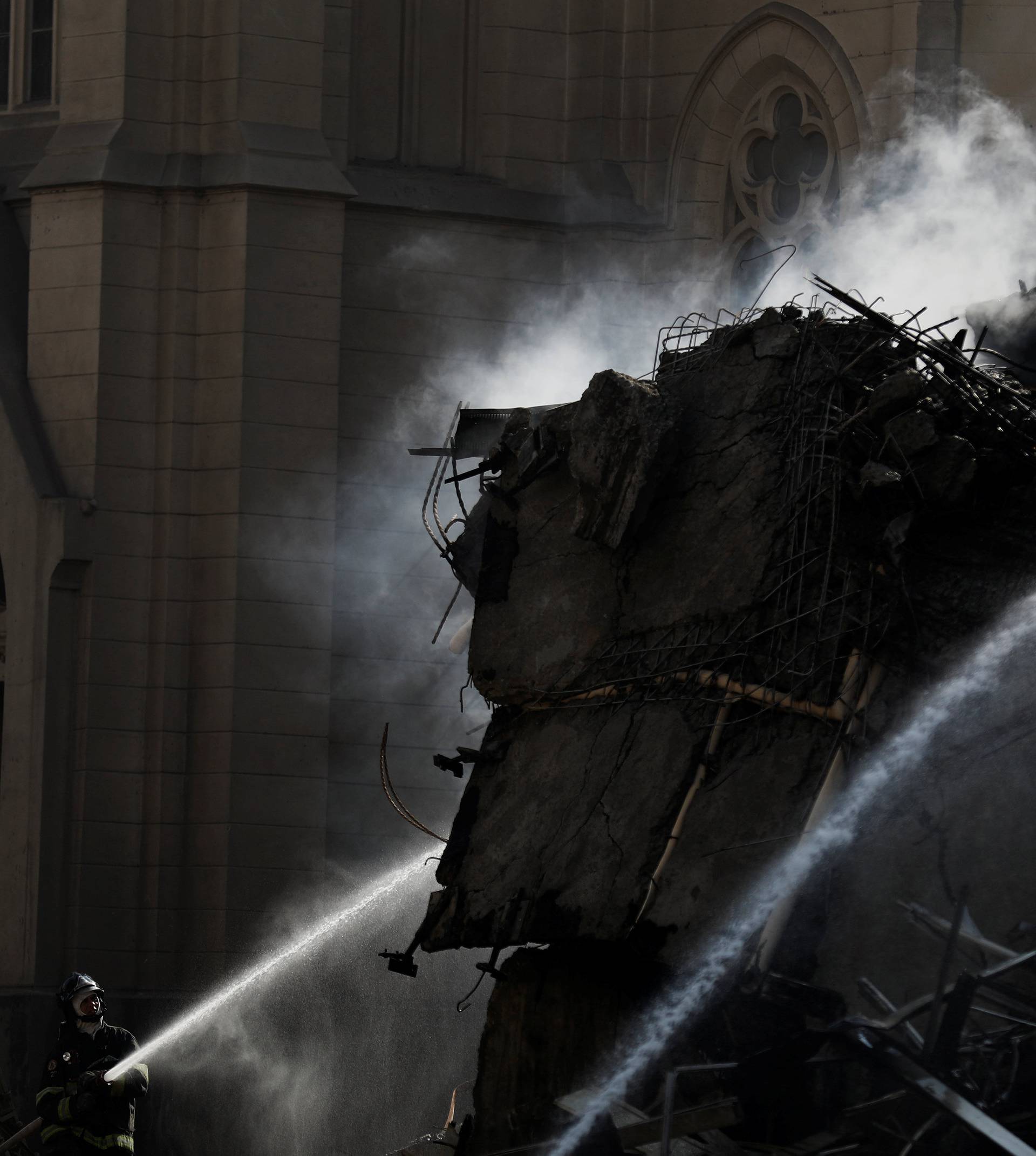 Firefighters try to extinguish the fire of a building that caught fire and collapsed in the center of Sao Paulo
