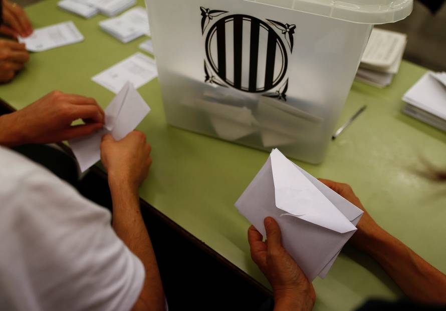 Poll workers count ballots after polls closed at a polling station for the banned independence referendum in Barcelona