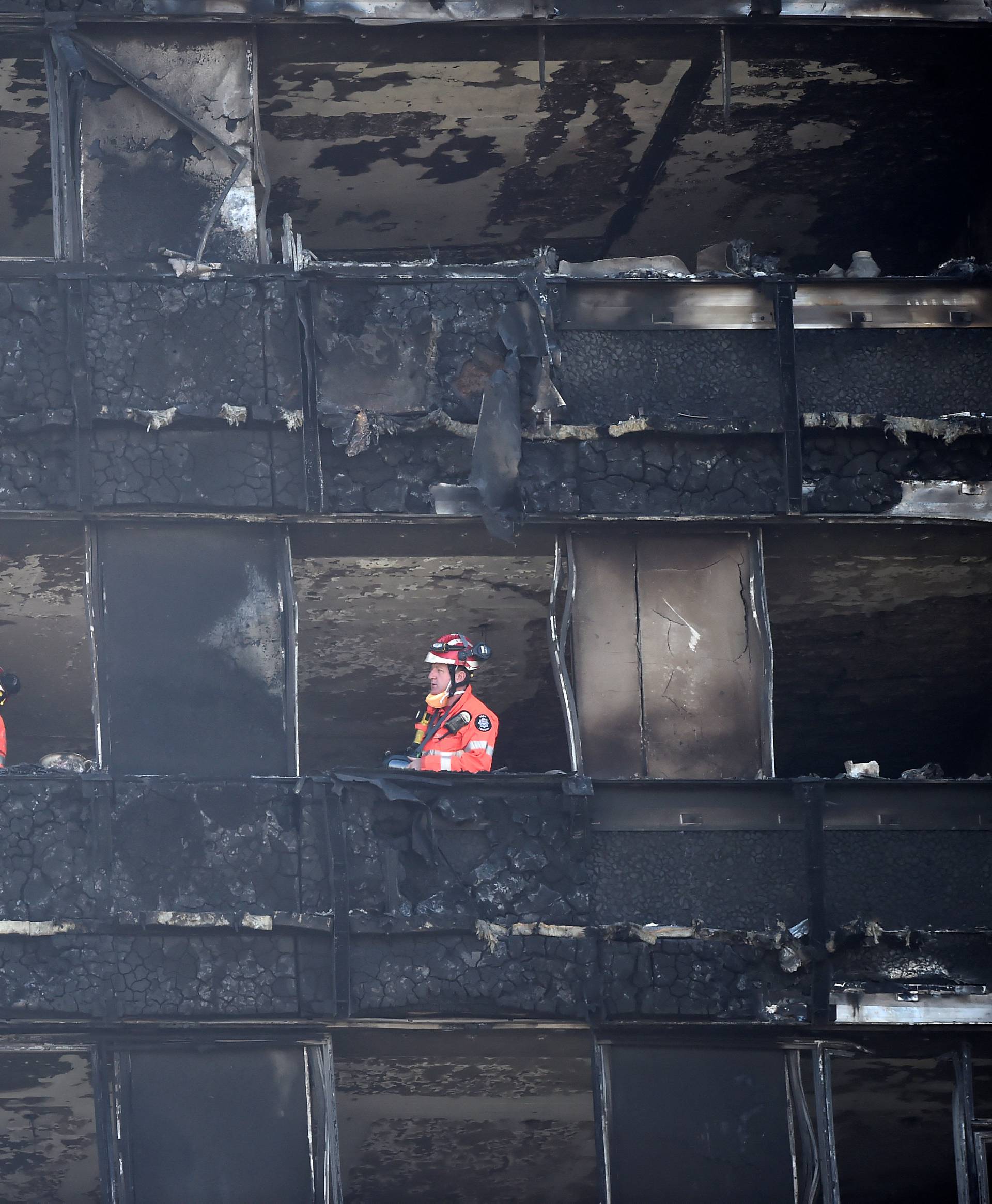 Members of the emergency services work inside the charred remains of the Grenfell apartment tower block in North Kensington