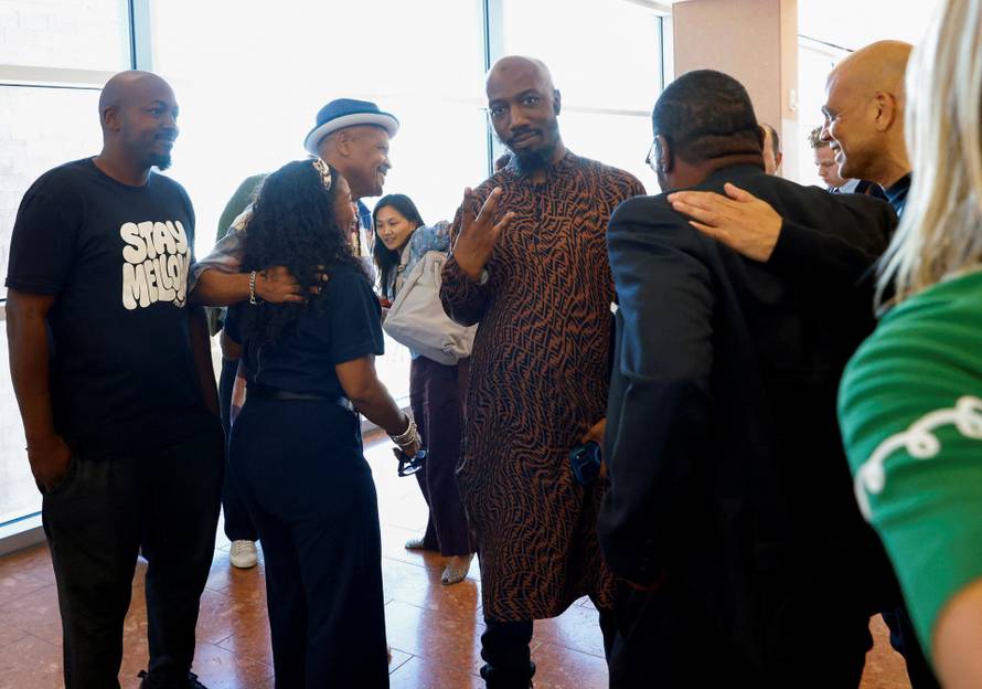 Friends and family members of rapper Tupac Shakur, and Darryl Harper, who says he is Shakur's music producer, celebrate outside a courtroom after a jury found Duane Davis guilty in the 1996 killing of Shakur