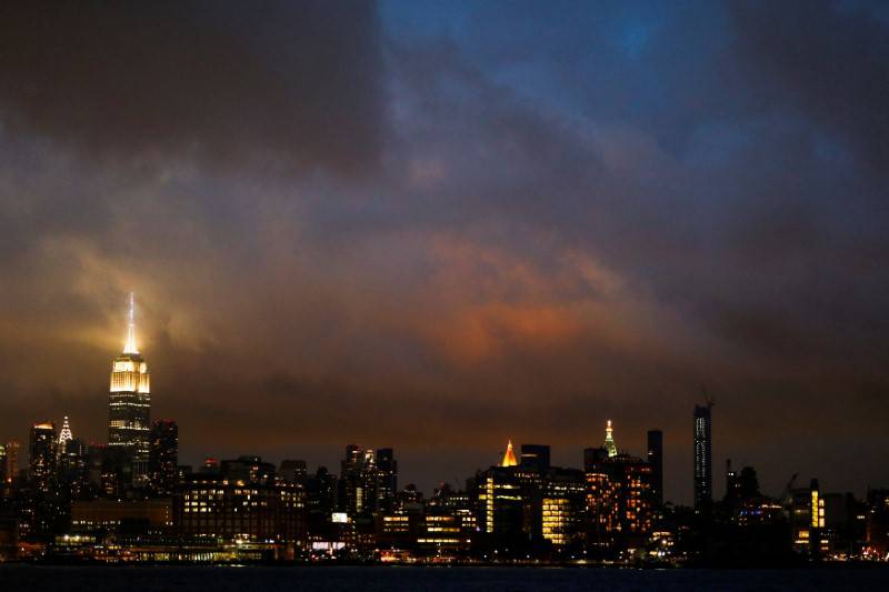 A low level cloud formation hovers over New York's Empire State Building and the skyline of midtown Manhattan as seen across the Hudson River in Hoboken, New Jersey
