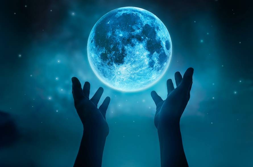 Abstract hands while praying at blue full moon with stars