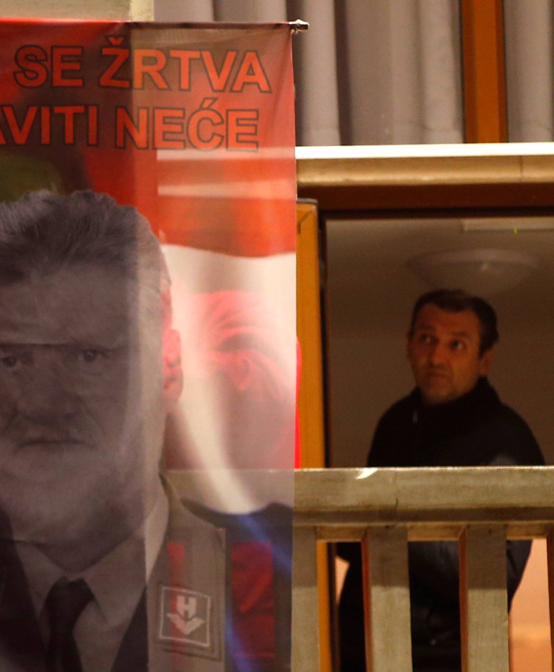 Bosnian Croats hang a flag displaying a portrait of General Slobodan Praljak in Mostar