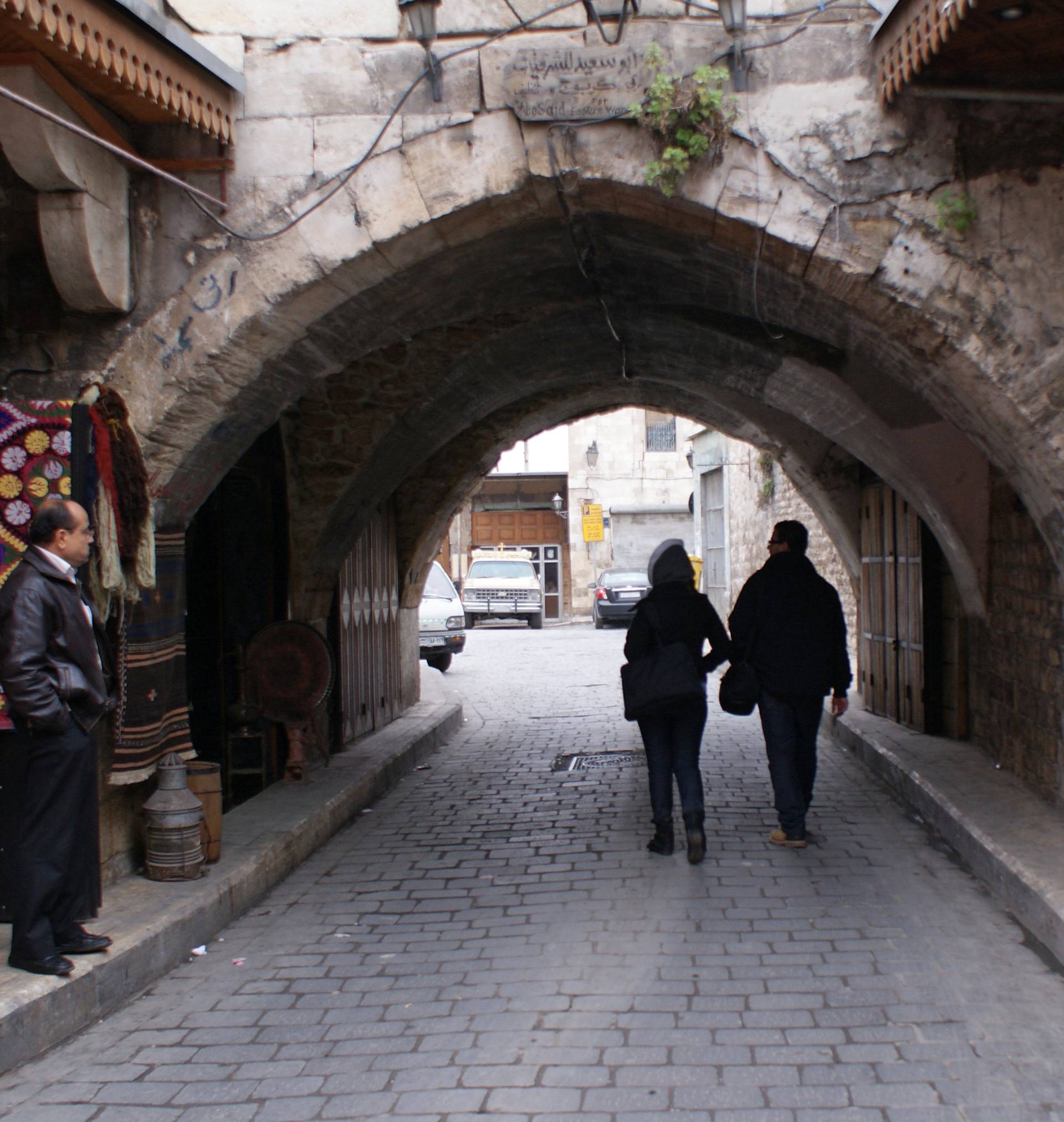 People walk along an alley in al-Jdeideh neighbourhood, in the Old City of Aleppo