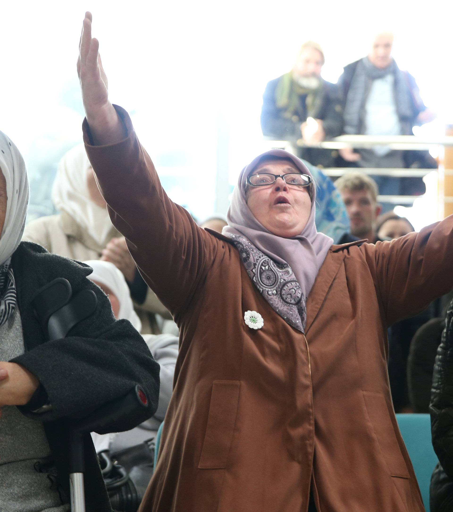 A woman reacts as she watches a television broadcast of the court proceedings of former Bosnian Serb general Ratko Mladic in the Memorial centre Potocari near Srebrenica