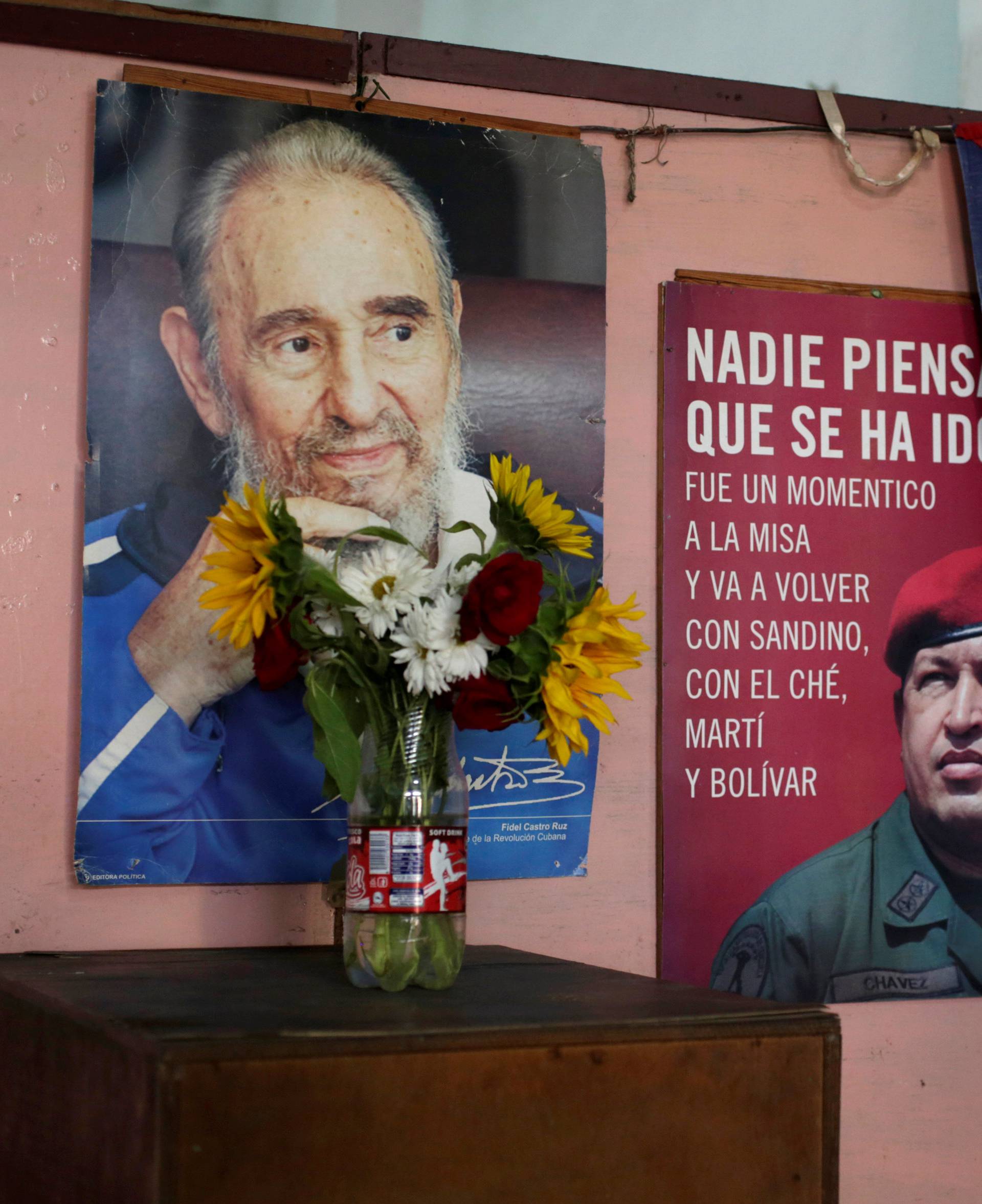 Pictures of Cuba's former president Fidel Castro and Venezuela's late president Hugo Chavez are seen on a wall near a Cuban flag inside a state office in Havana, Cuba
