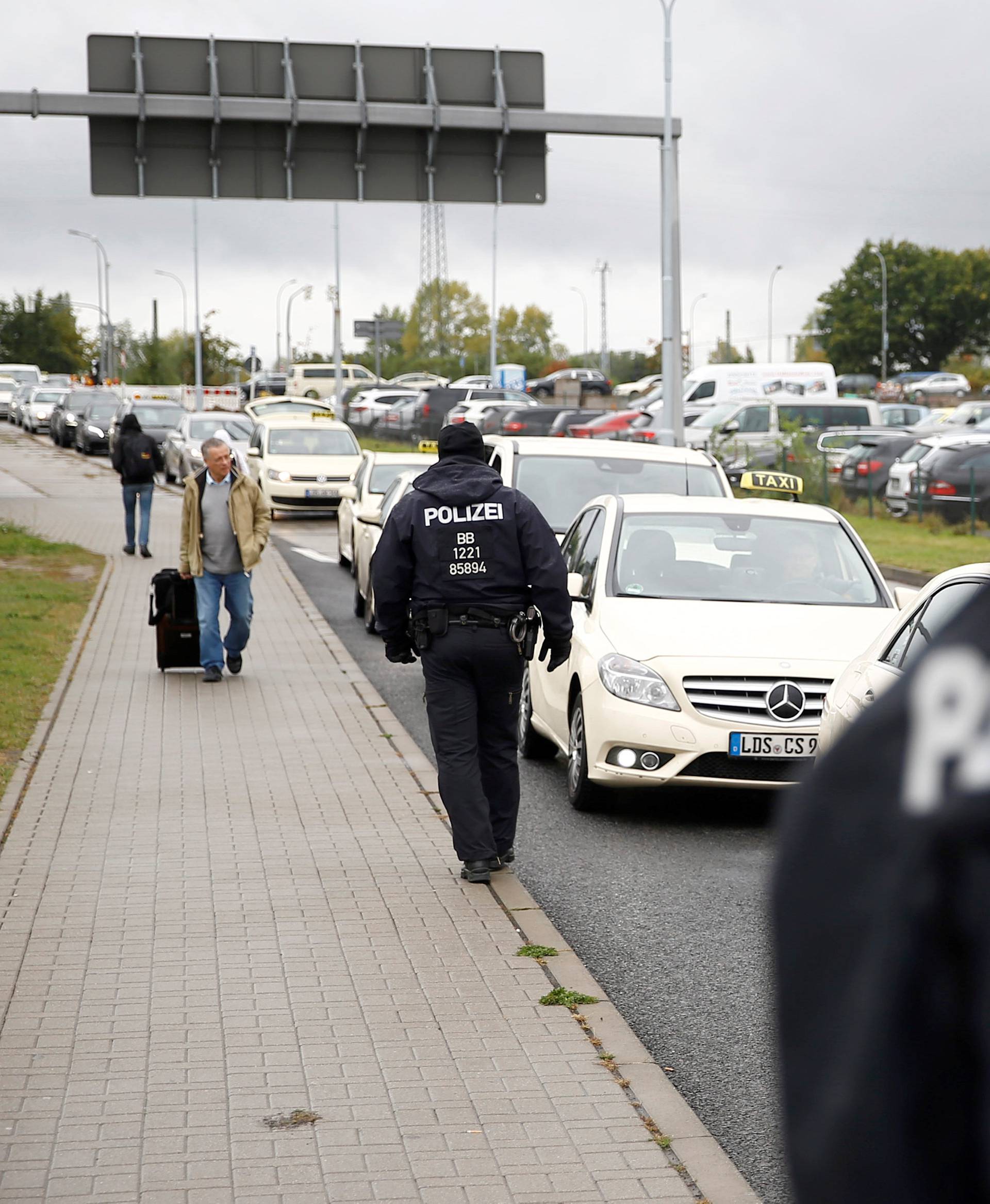 German policemen check cars on the entrance to Berlin-Schoenefeld airport, in Schoenefeld