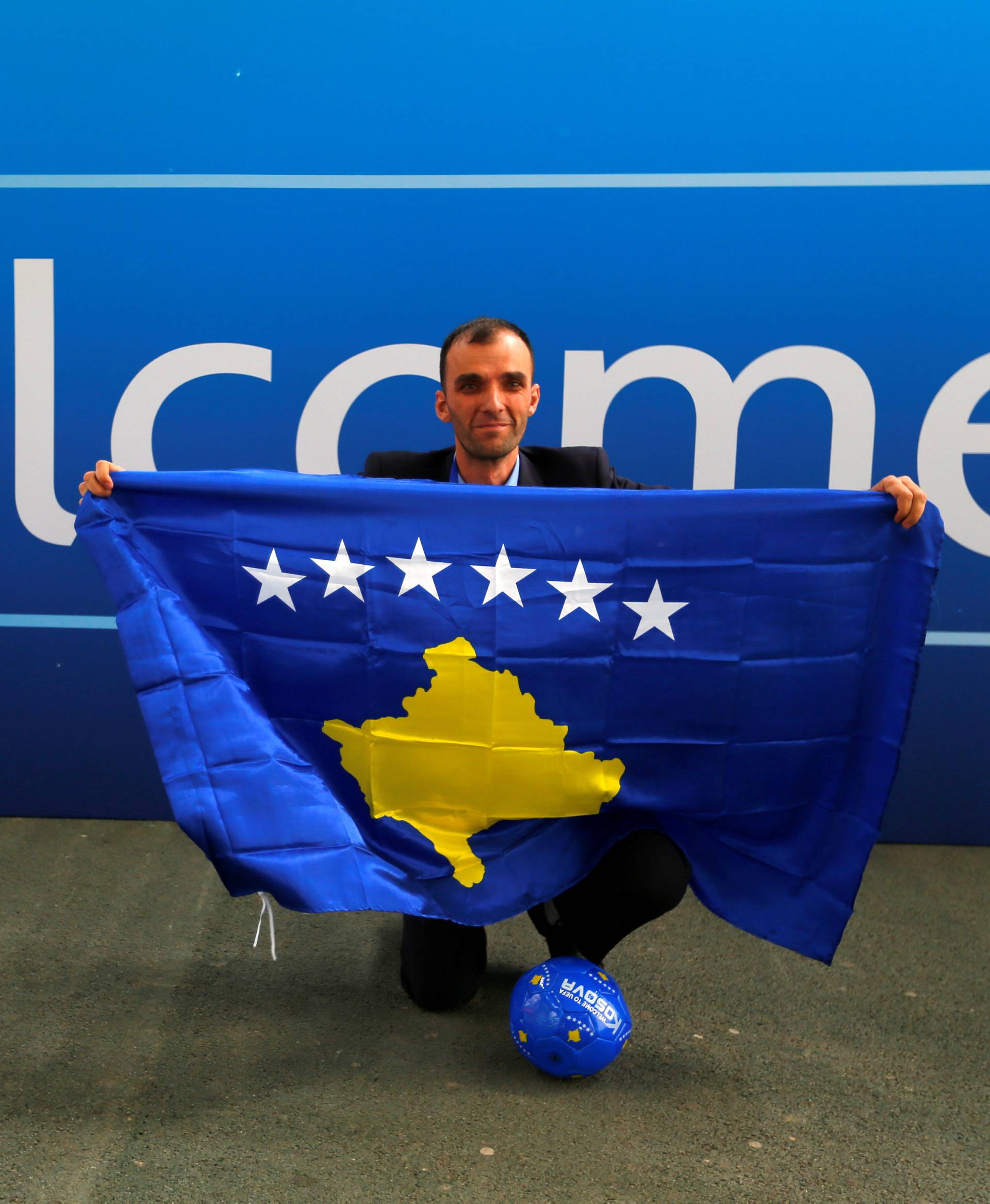 A member of the Kosovo media team celebrates outside the convention centre where the European football group UEFA admitted Kosovo as its newest member in Budapest