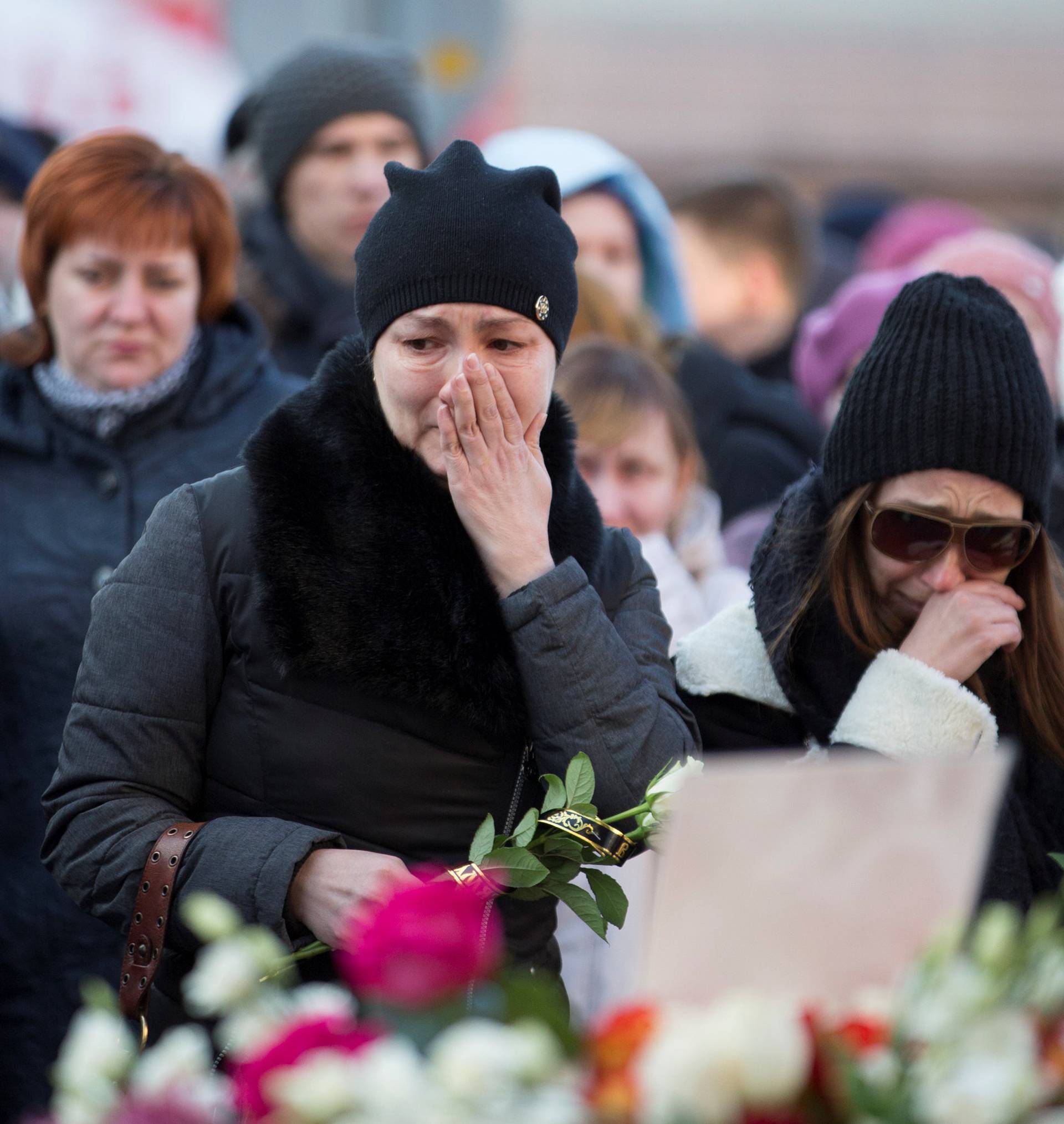 People mourn the victims of a shopping mall fire at a makeshift memorial in the Siberian city of Kemerovo