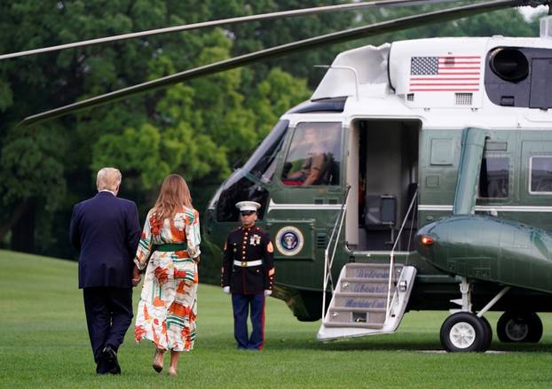 U.S. President Donald Trump and U.S. first lady Melania Trump walk to Marine One as they depart for London from the White House in Washington