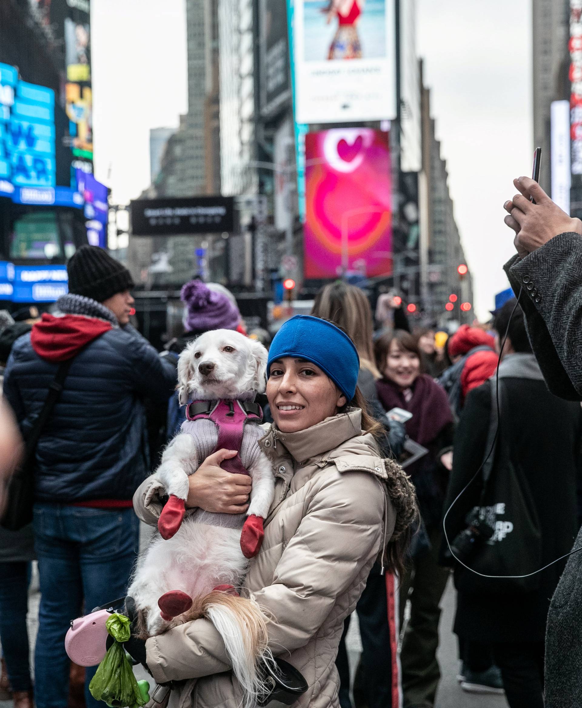 A reveler takes a picture with her dog theÂ NewÂ Year'sÂ EveÂ in Times Square inÂ the Manhattan