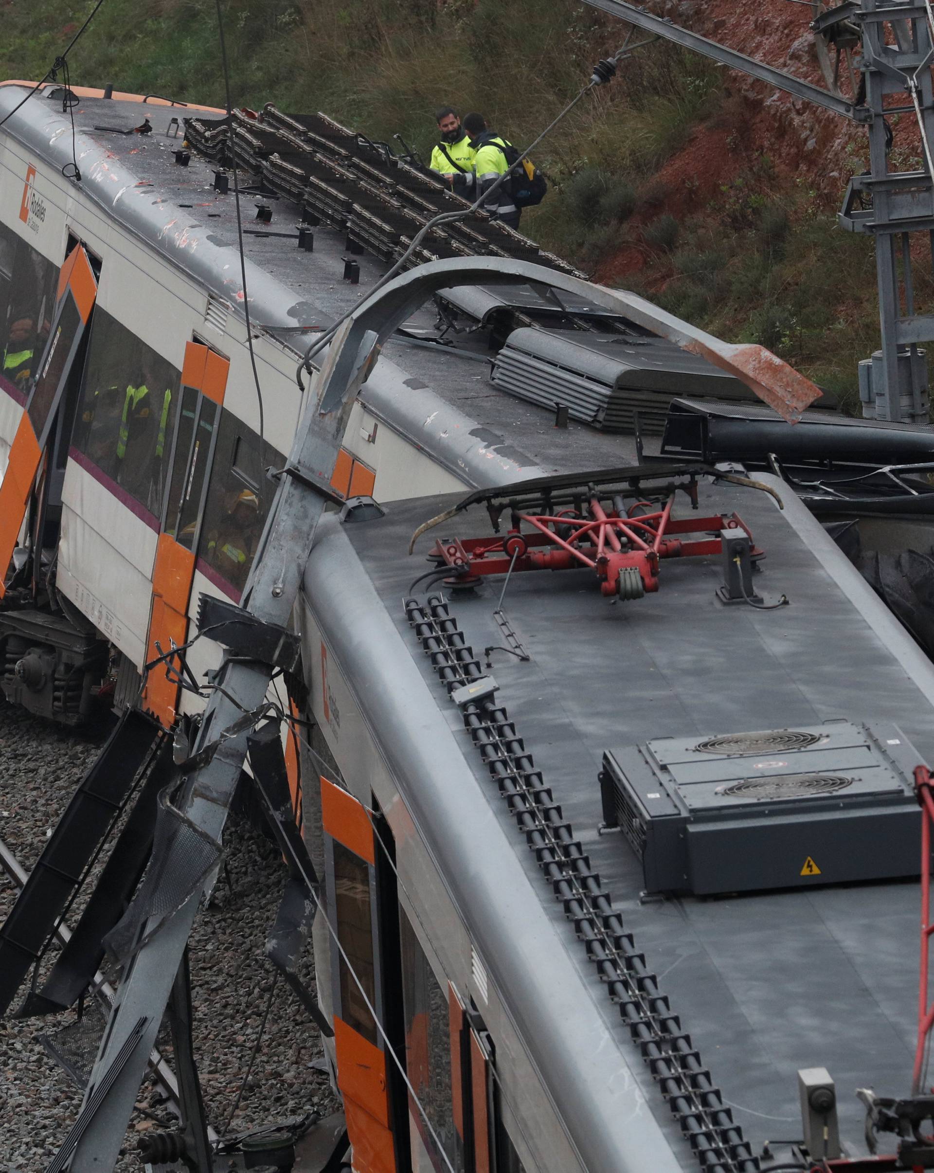 Rescue workers survey the scene after a commuter train derailed between Terrassa and Manresa outside Barcelona