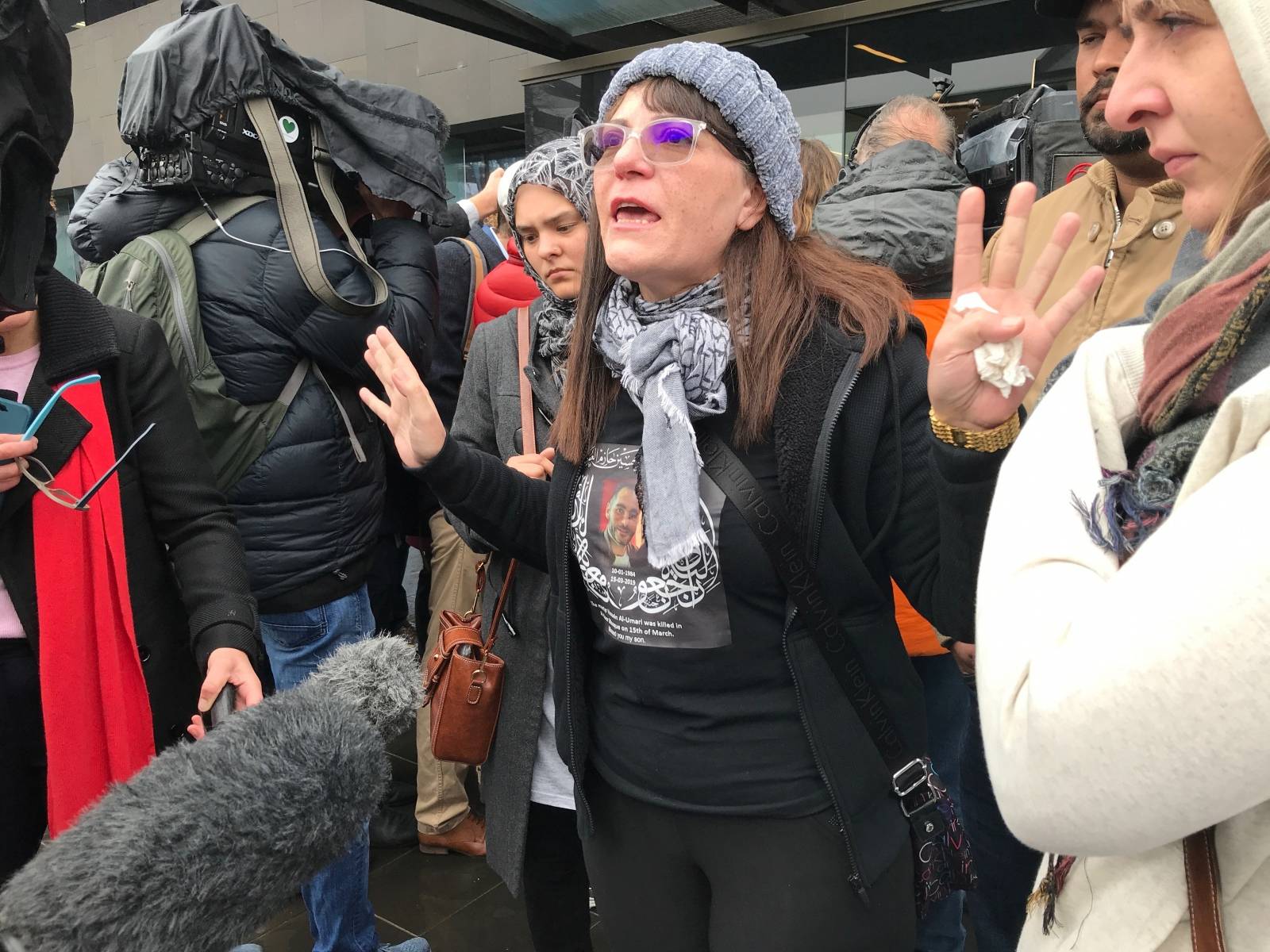 Janna Ezat, wearing a T-shirt in memorial of her son who was killed at Al Noor mosque on March 15, reacts outside the Christchurch High Court after accused gunman Brenton Tarrant pleaded not guilty to all charges, New Zealand