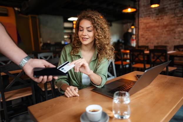 Young,Woman,Paying,With,Credit,Card,Using,Contactless,Payment,In