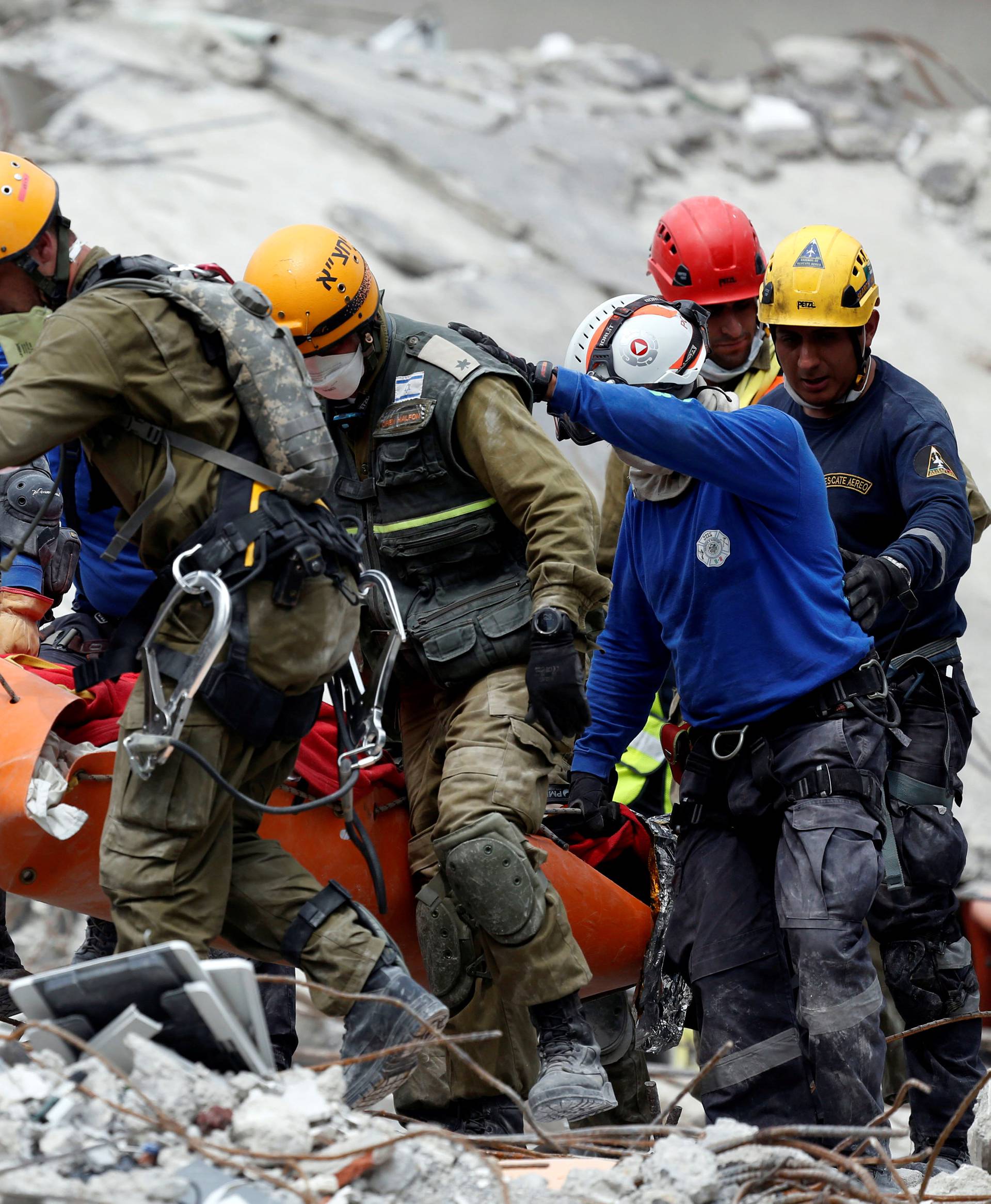 Members of Israeli and Mexican rescue teams carry a dead body after retrieving from a collapsed building after an earthquake in Mexico City