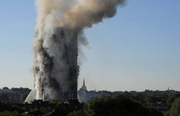 Smoke billows as firefighters deal with a serious fire in a tower block at Latimer Road in West London