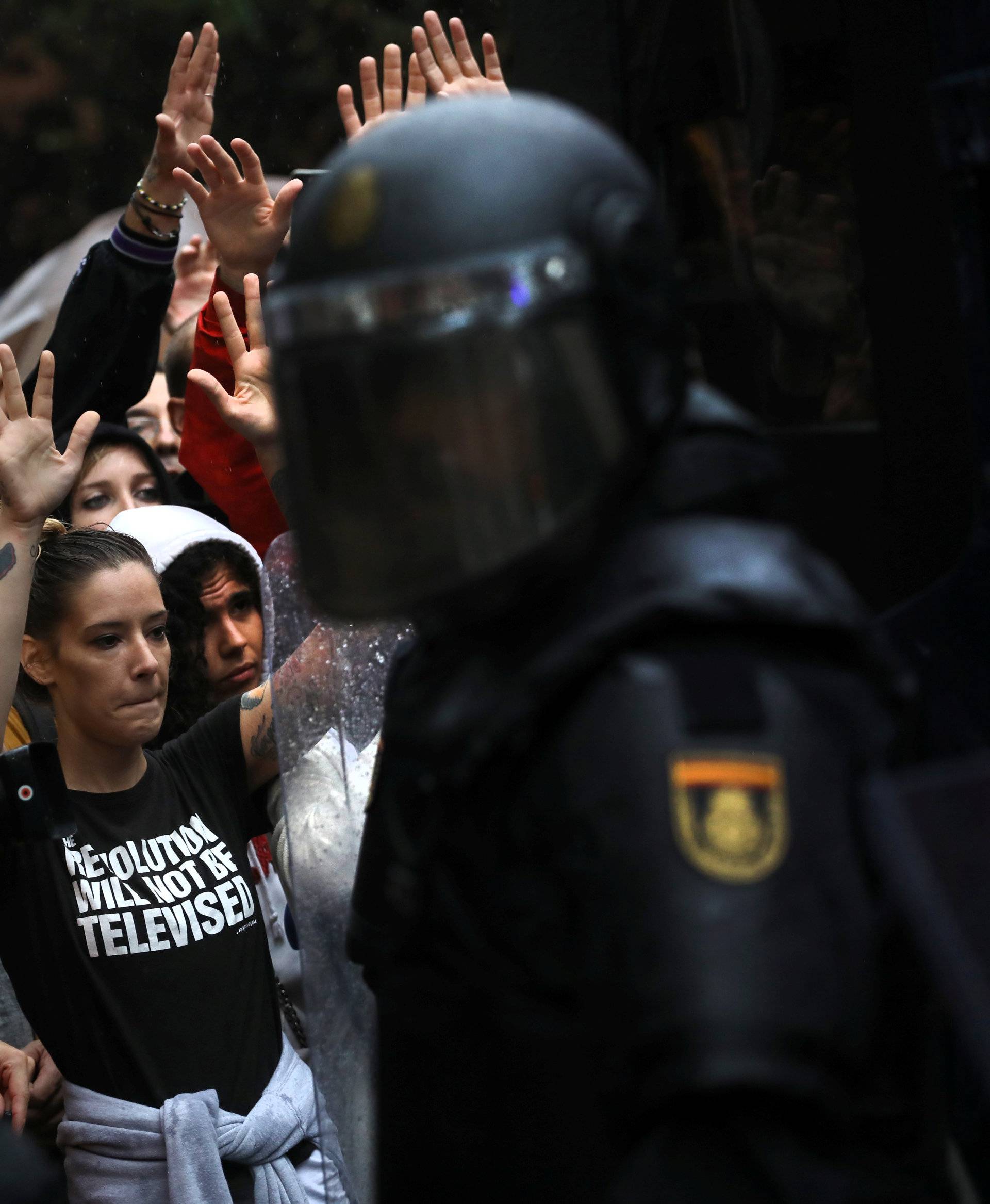 Demonstartors face riot police outside a polling station for the banned independence referendum in Barcelona