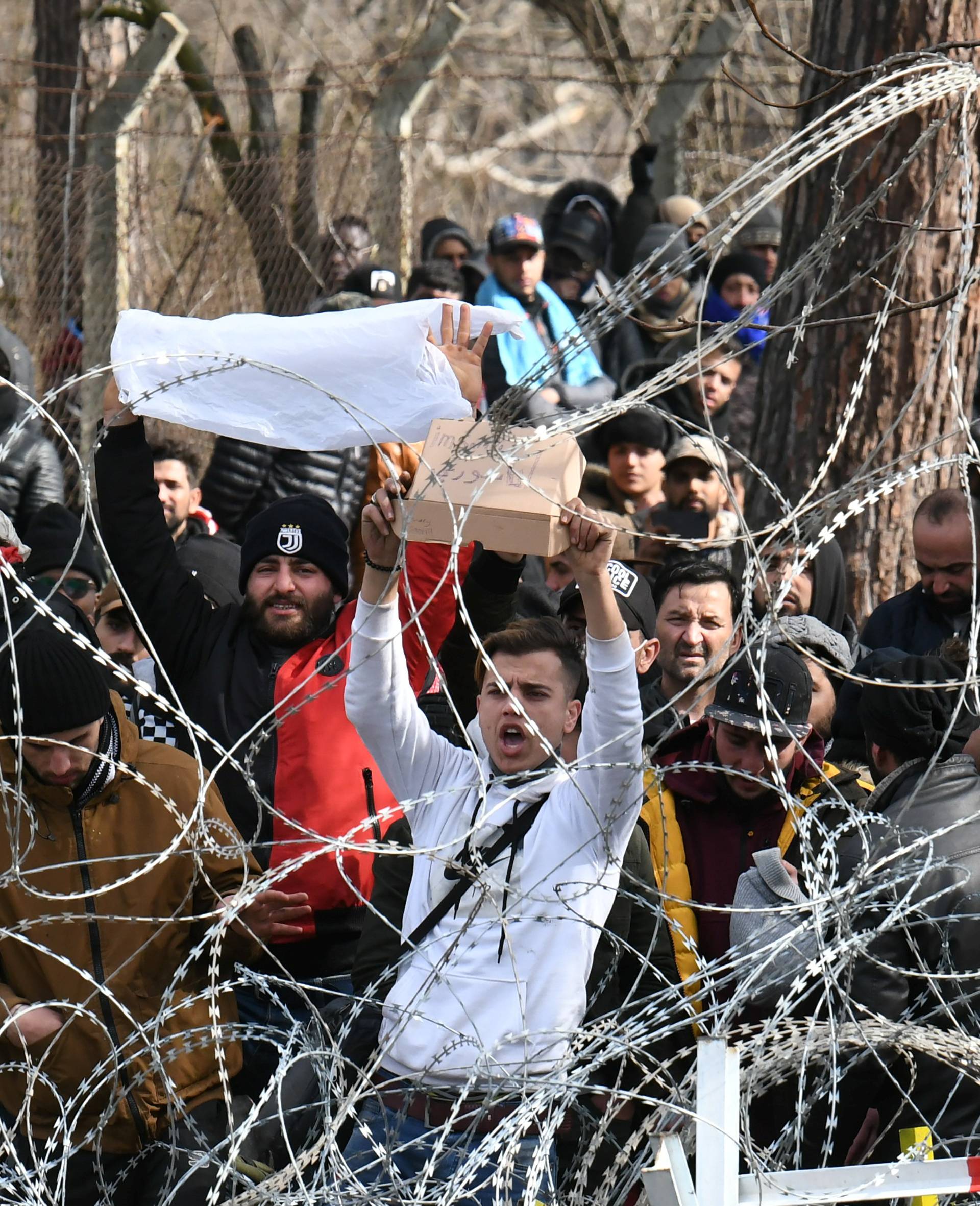 Migrants who want to cross into Greece from Turkey's Pazarkule border crossing shout slogans as they are gathered at the borderline, in Kastanies