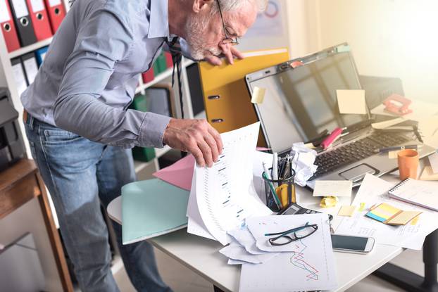 Disorganized,Businessman,Looking,For,Documents,On,His,Desk,,Light,Effect