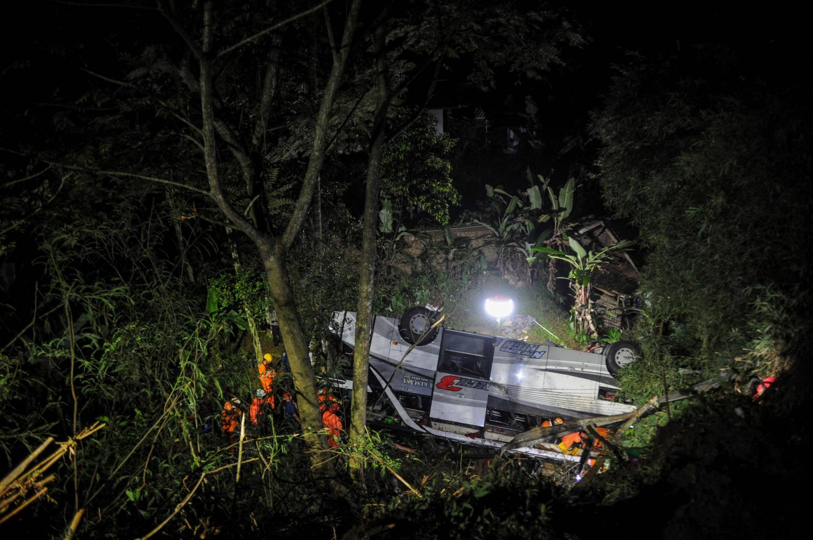 Rescue personnel work at the crash site after a bus fell into a ravine in Sumedang, Indonesia