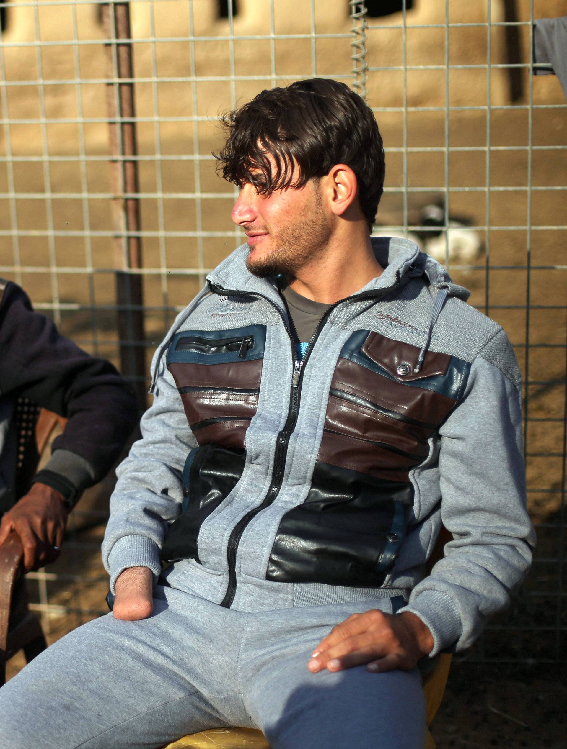 Azad Hassan and his brother Mohammad, whose hands were chopped off by Islamic State militants, sit next to each other at Nimrud village, south of Mosul