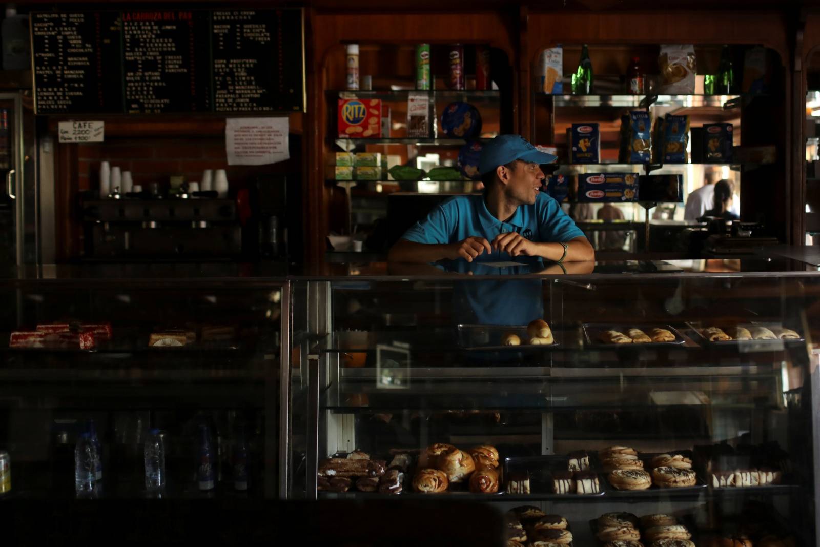 A worker stands inside a bakery during an ongoing blackout in Caracas