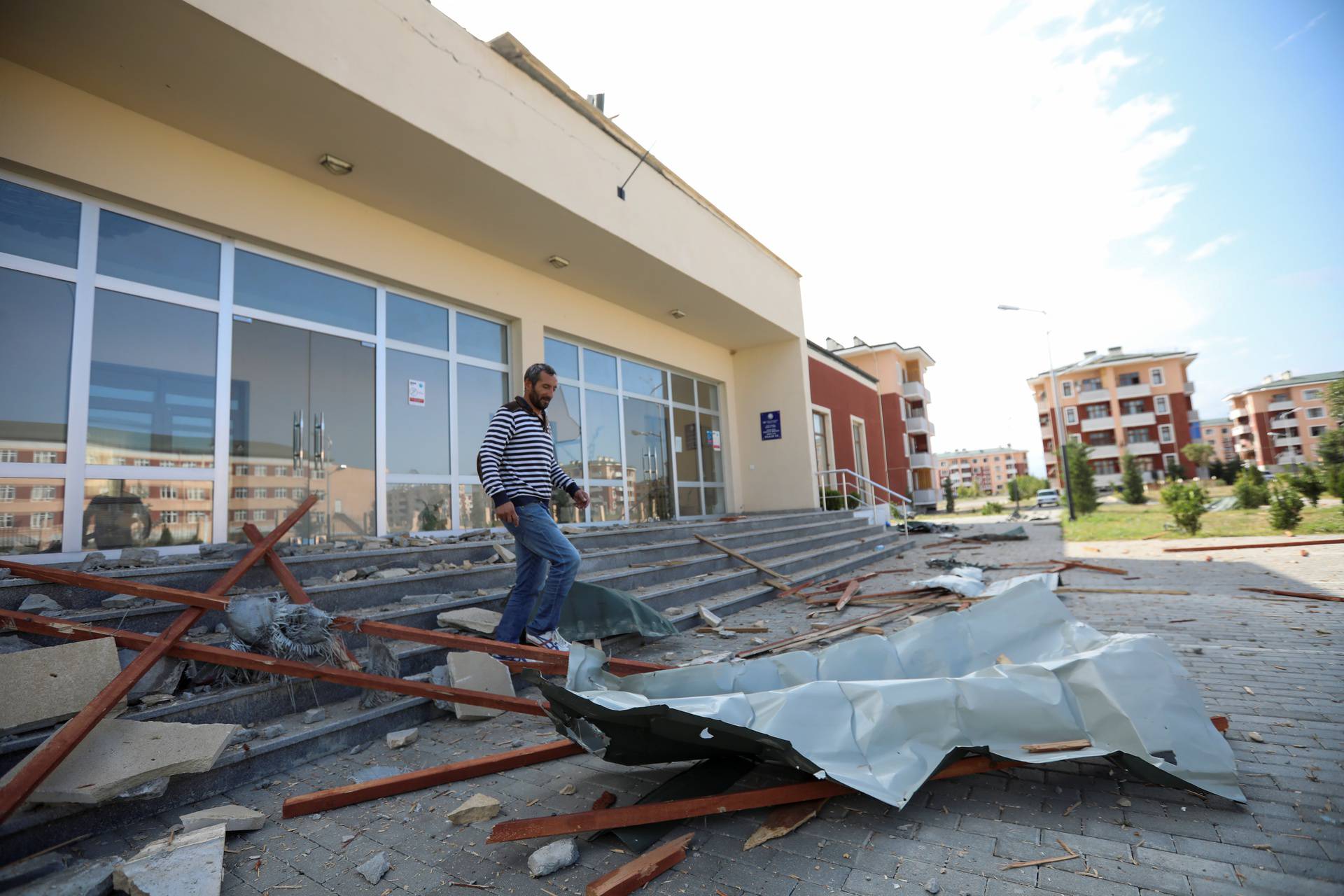 A man walks through the debris from a building that was allegedly damaged by recent shelling during the fighting over the breakaway region of Nagorno-Karabakh, in Shikharkh