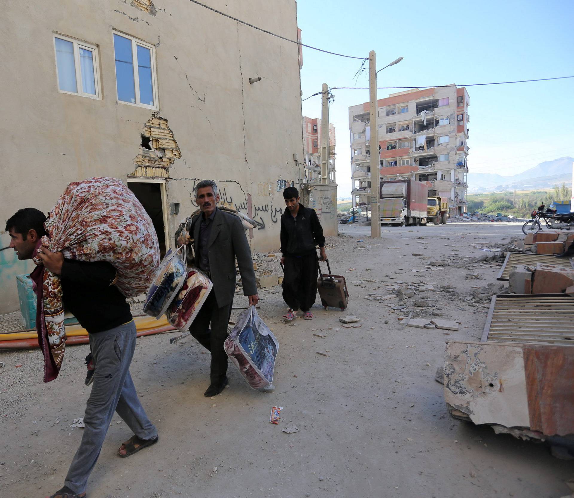 People carry their belongings following an earthquake in Sarpol-e Zahab county in Kermanshah
