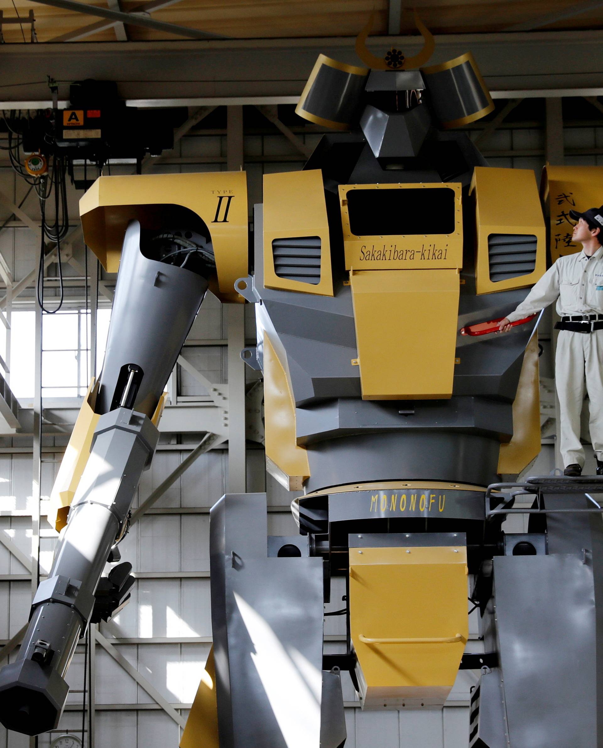 Sakakibara Kikai's engineer Go Sakakibara poses with the bipedal robot Mononofu during its demonstration at its factory in Shinto Village