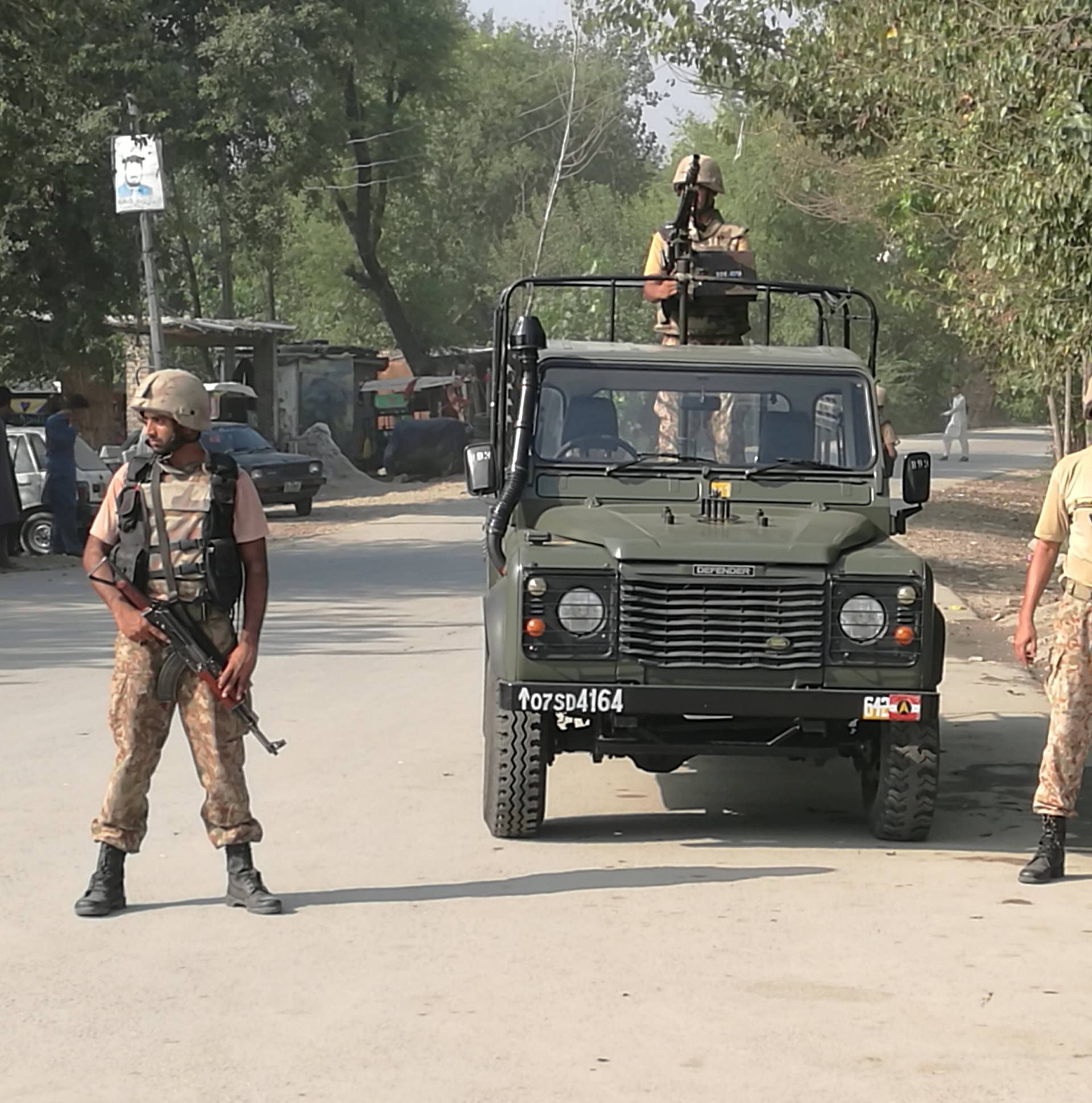 Army soldiers stand guard a street after suicide bombers attacked a Christian neighbourhood in Khyber Agency near Peshawar