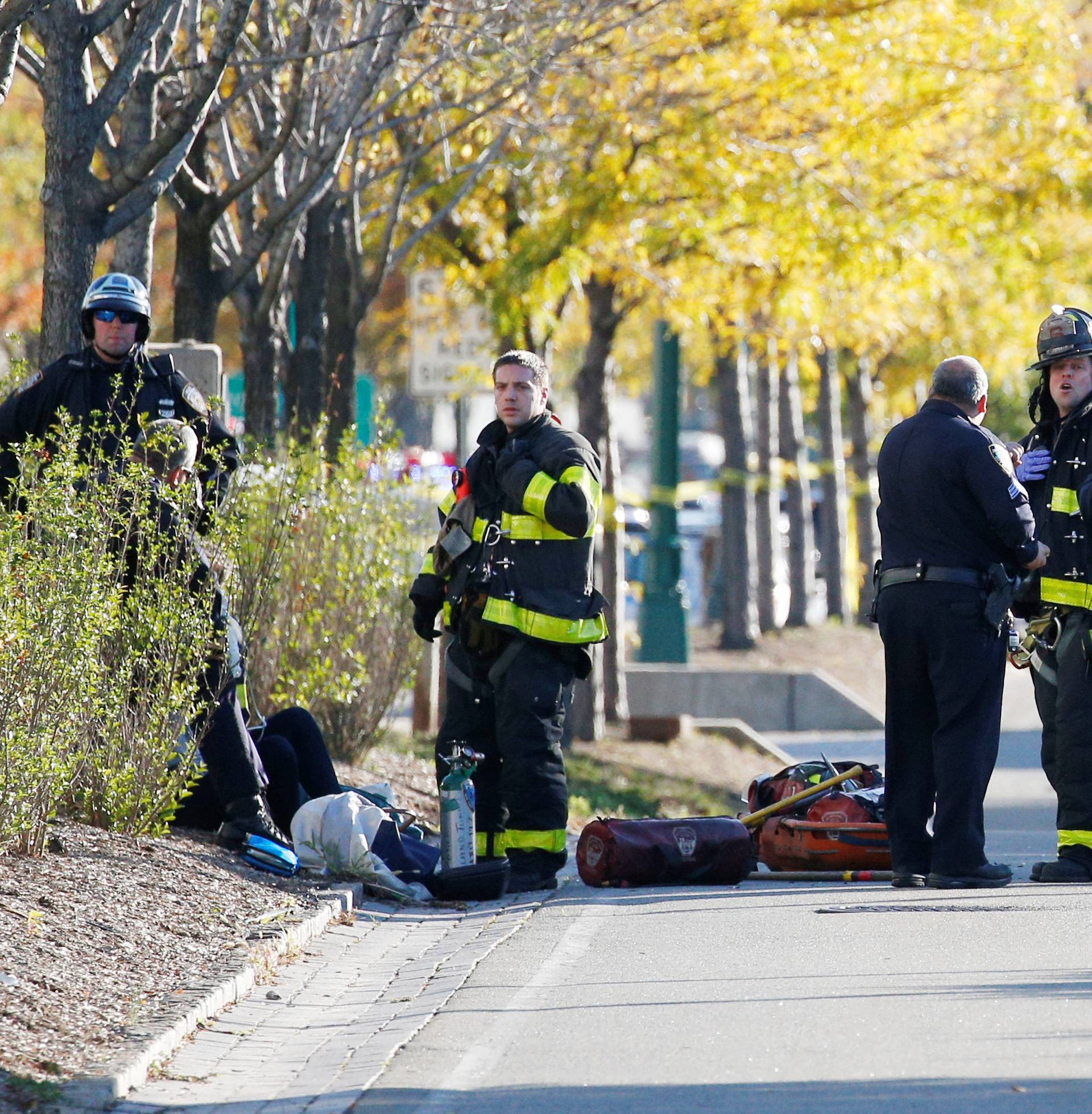 New York city first responders stand at the crime scene on a bike path in lower Manhattan in New York