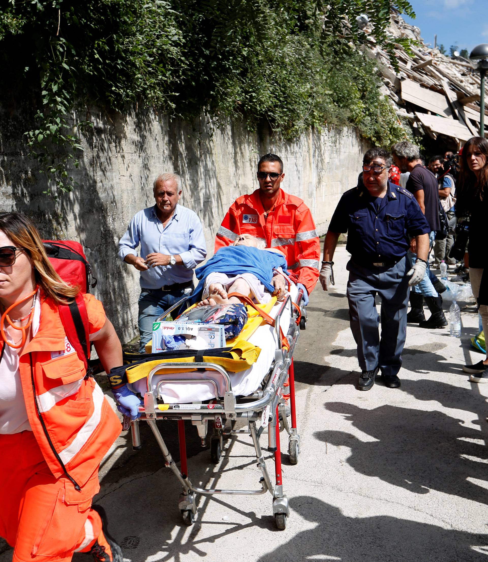 An injured person is carried away on a stretcher following an earthquake at Pescara del Tronto
