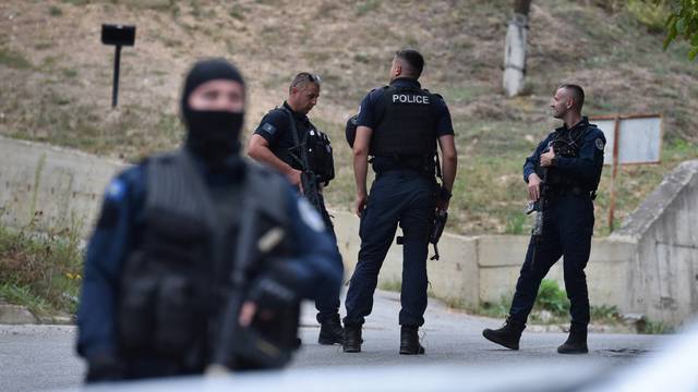 Police officers patrol in the aftermath of a shooting, on the road to Banjska village