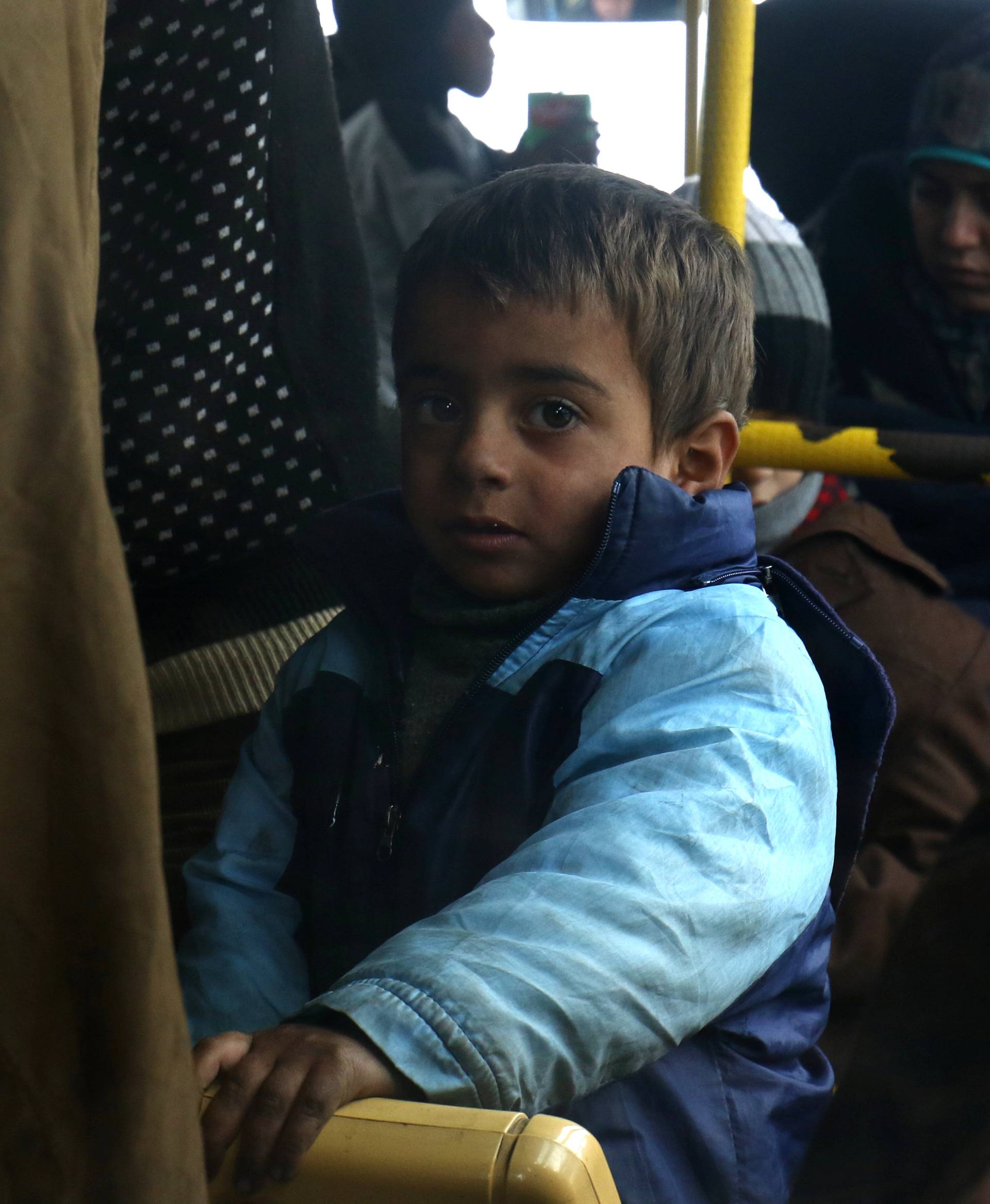 Evacuees from the Shi'ite Muslim villages of al-Foua and Kefraya ride a bus at insurgent-held al-Rashideen in Aleppo province