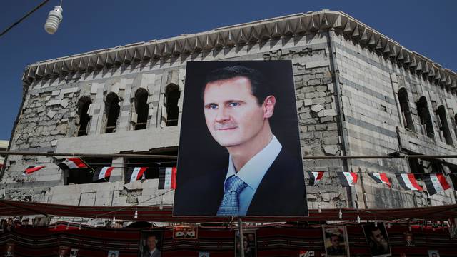 FILE PHOTO: A banner depicting Syrian President Bashar al-Assad in Douma, outside Damascus, Syria