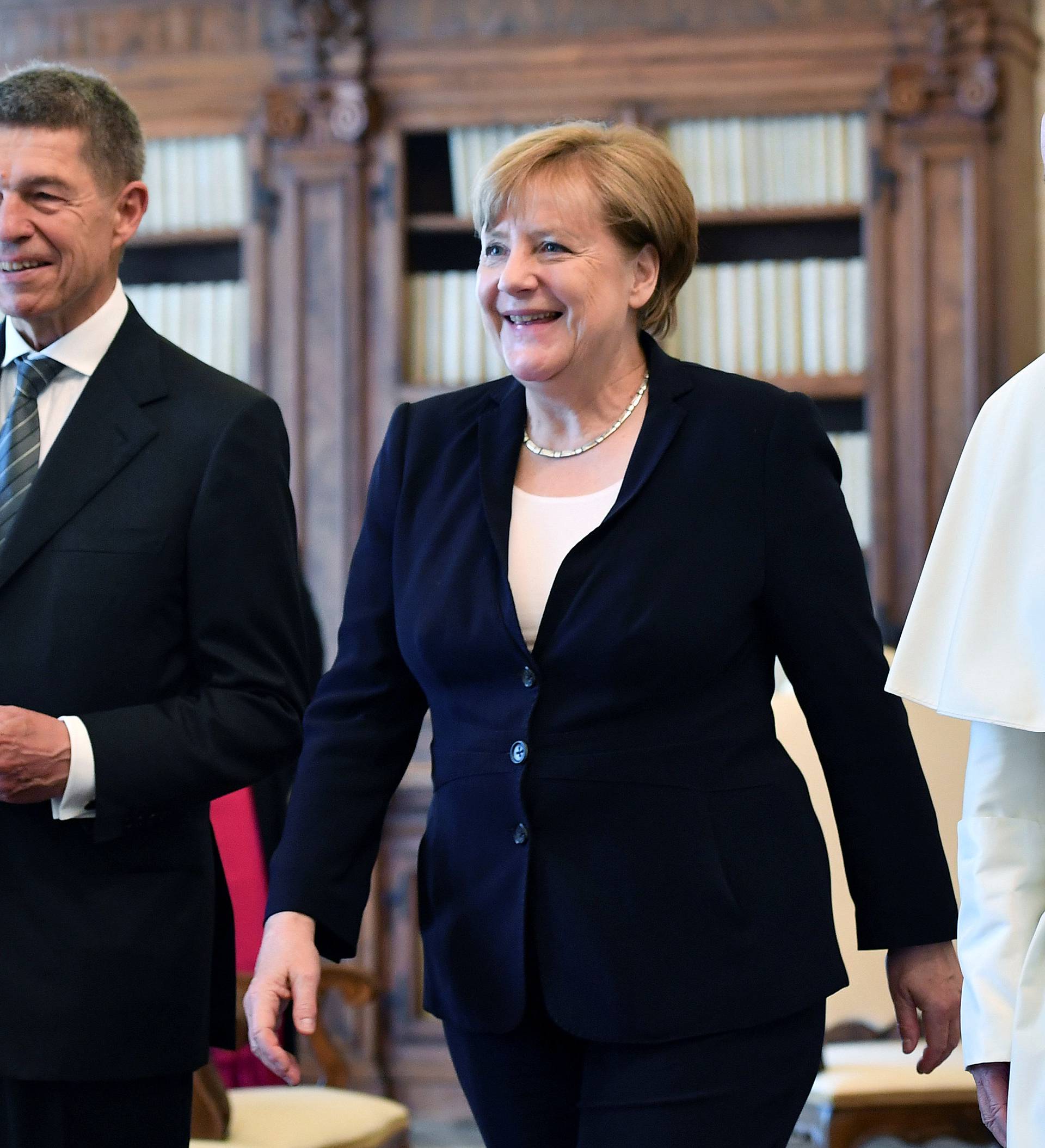 German Chancellor Merkel and her husband Sauer walk with Pope Francis during a meeting at the Vatican
