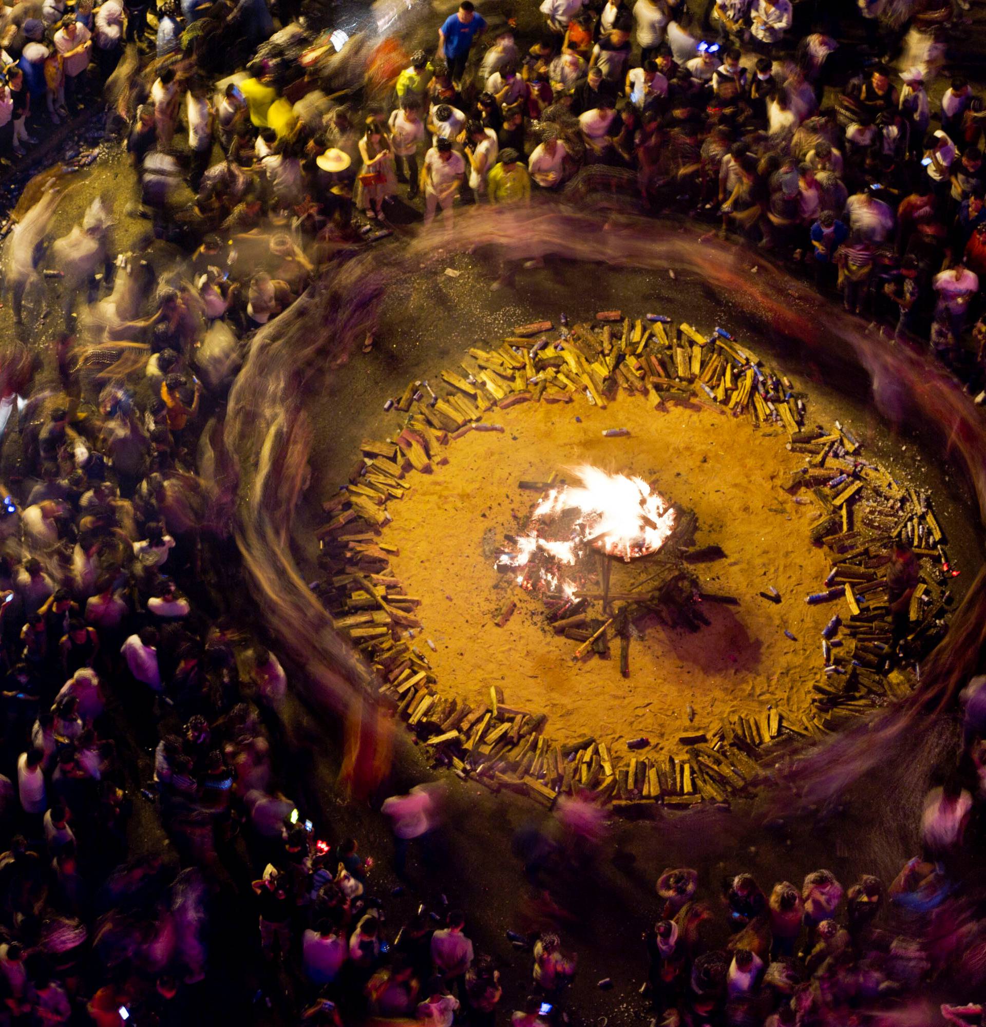 People surround bon fire during a torch festival in Shilin county