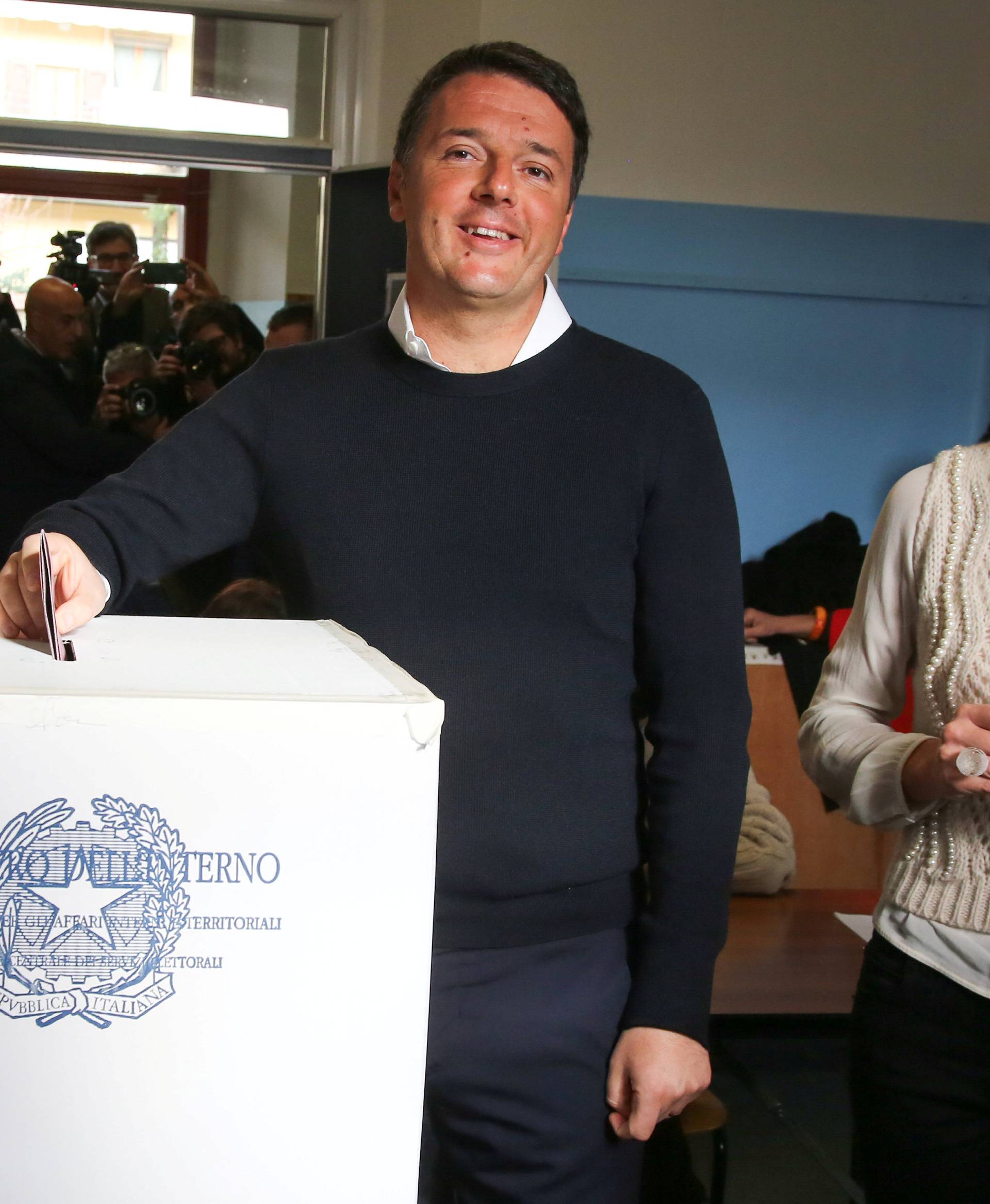 Italian Prime Minister Matteo Renzi casts his vote for the referendum on constitutional reform as he is flanked by his wife Agnese, in Pontassieve